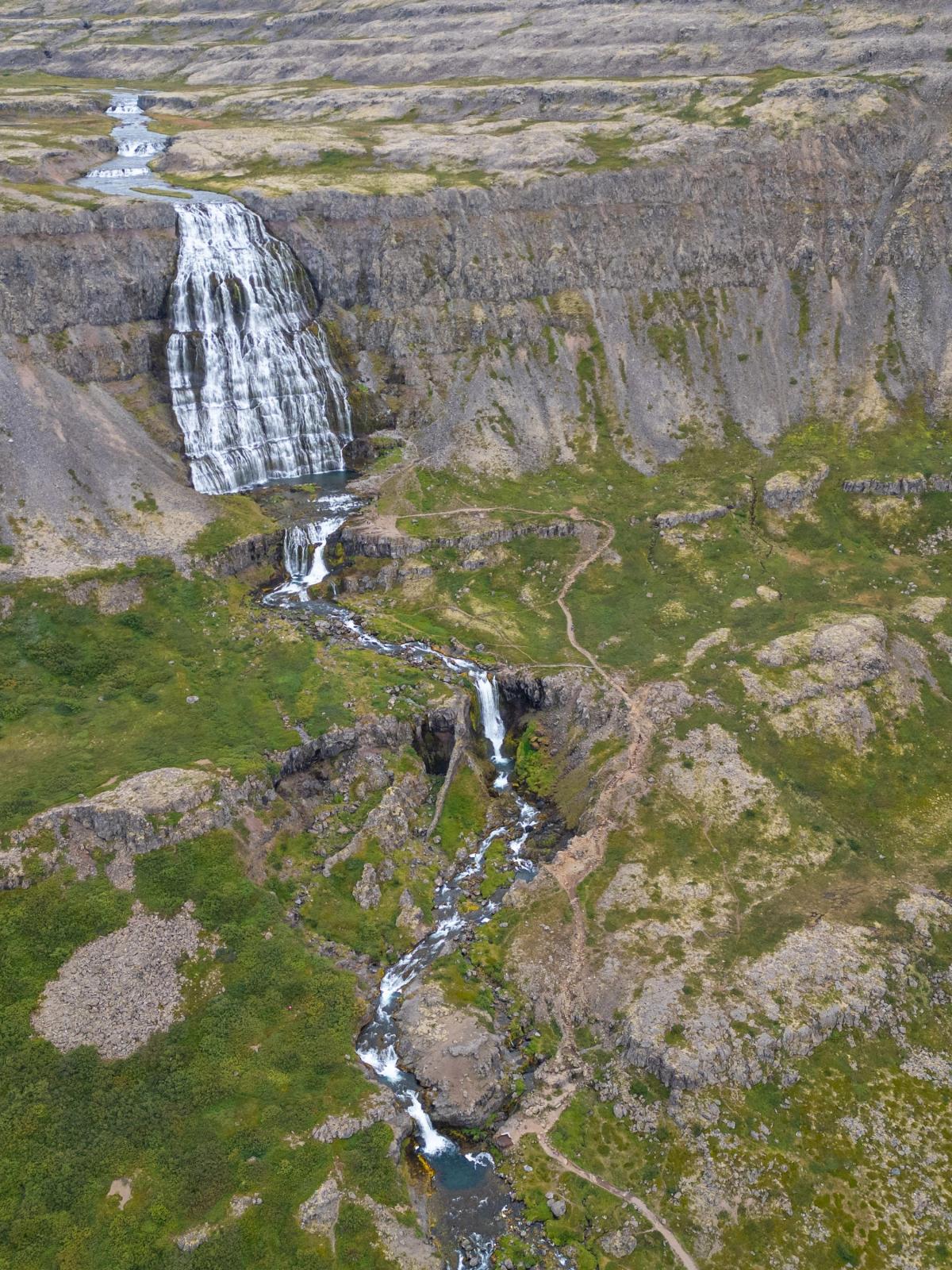una vista aérea de una cascada en medio de una montaña .