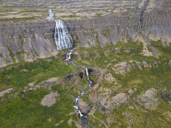 an aerial view of a waterfall in the middle of a mountain .