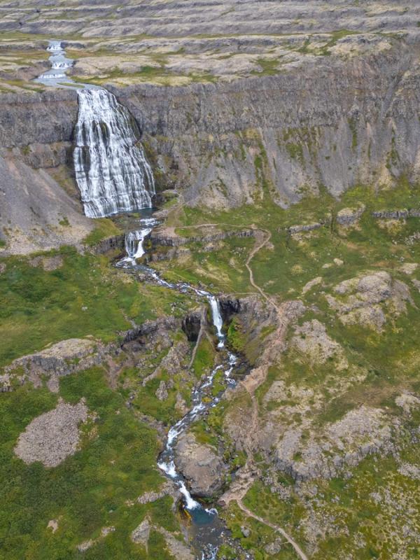 an aerial view of a waterfall in the middle of a mountain .