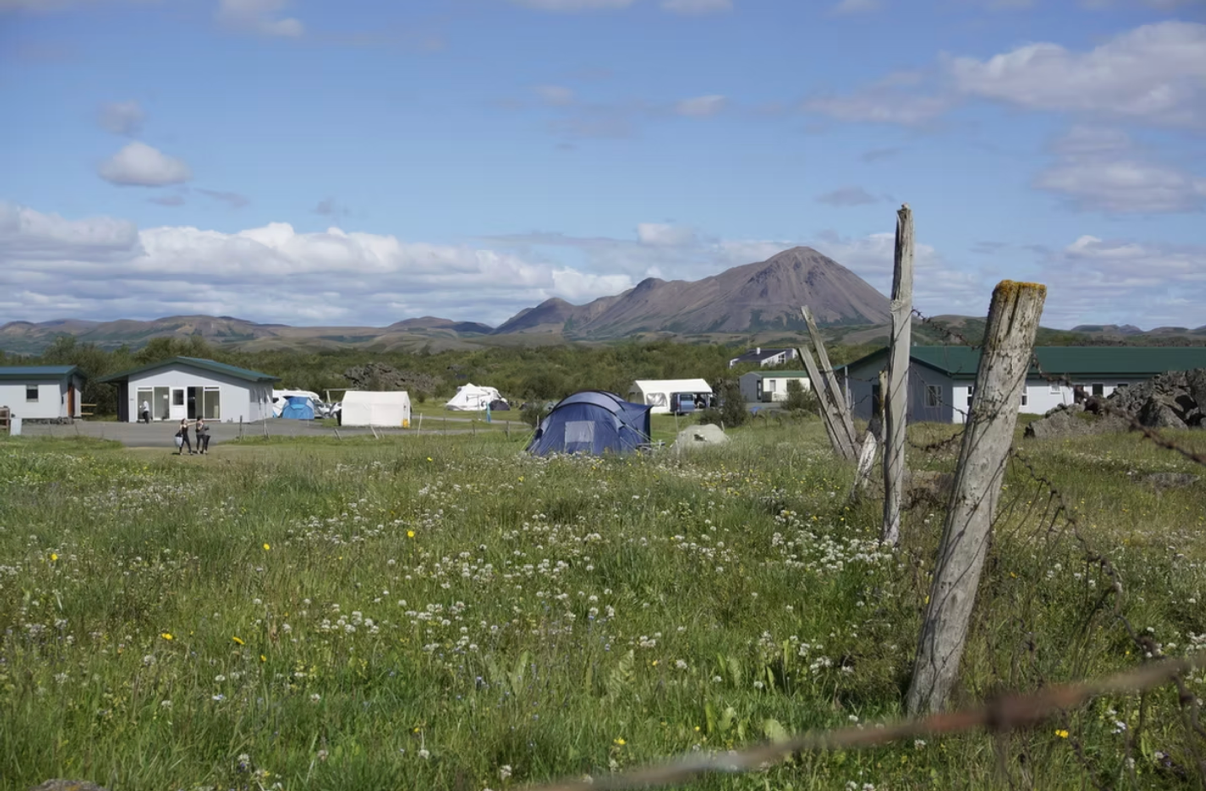 una carpa azul se encuentra en medio de un campo de hierba