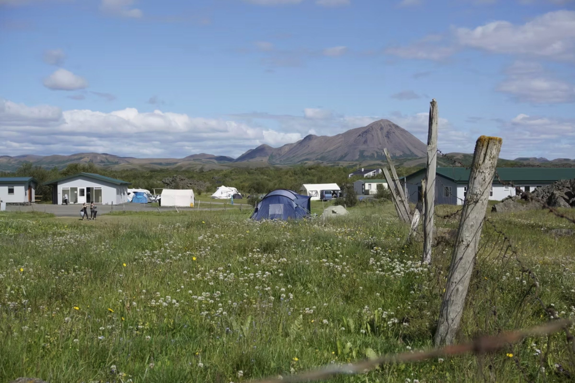 una carpa azul se encuentra en medio de un campo de hierba