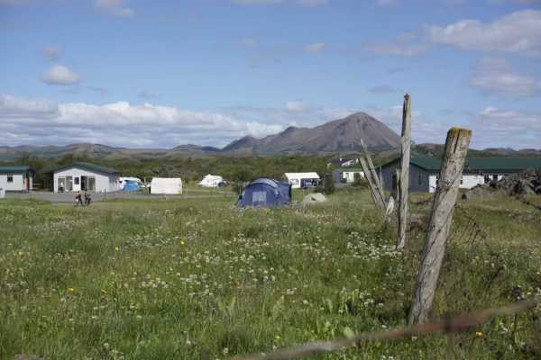 una carpa azul se encuentra en medio de un campo de hierba