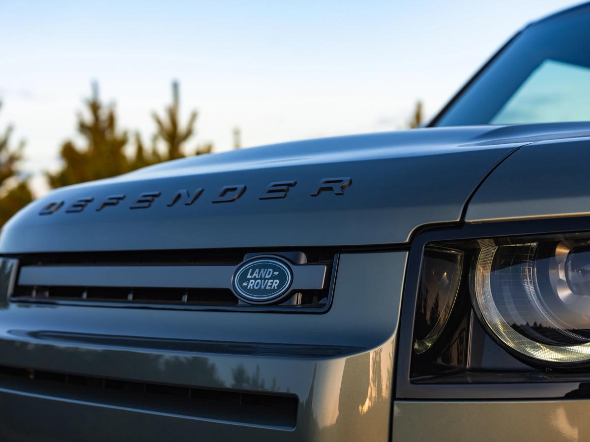 Primer plano del emblema y la parrilla del Land Rover Defender Primer plano del emblema y la parrilla de un Land Rover Defender de alquiler en Islandia, disponible en Go Car Rental