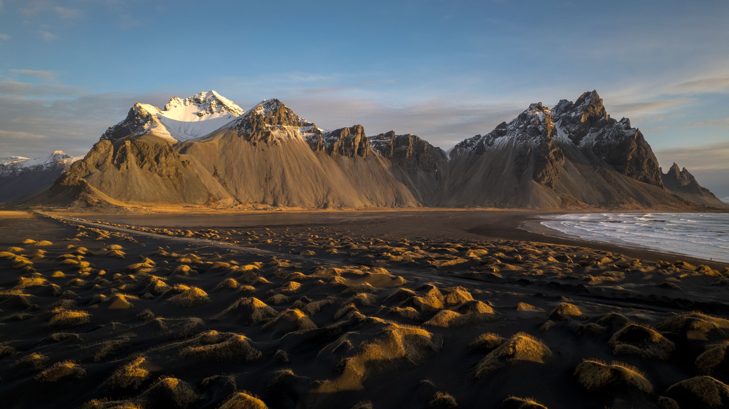 there are mountains in the background and a beach in the foreground at vestrahorn in east iceland.