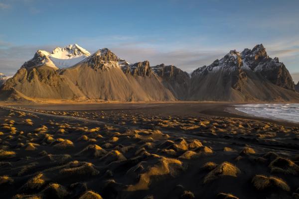 there are mountains in the background and a beach in the foreground at vestrahorn in east iceland.