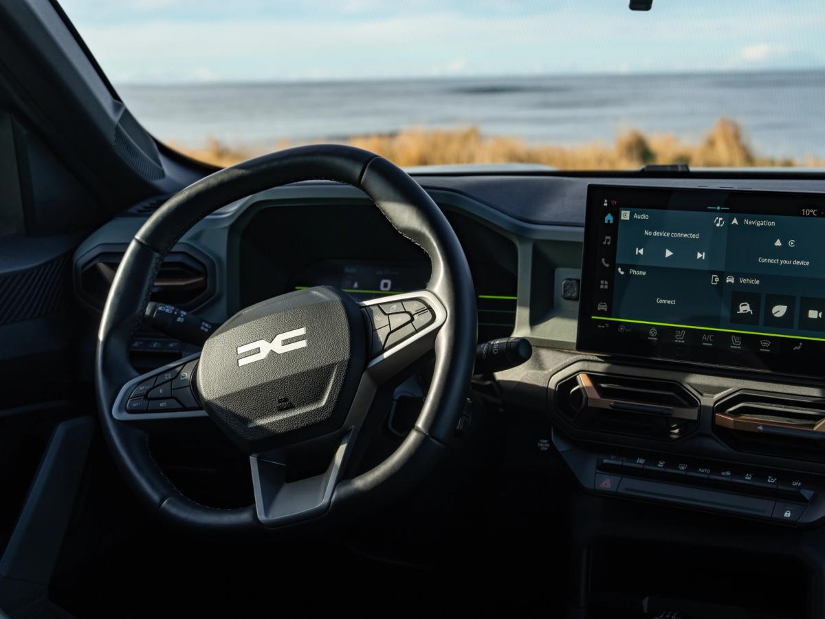 Ecrã tátil do painel do Duster Painel de instrumentos de um Dacia Duster, com volante e ecrã tátil, virado para uma vista para o mar