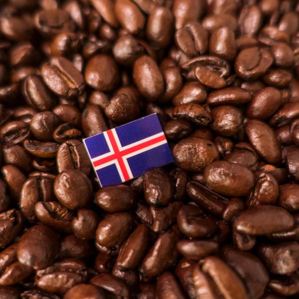 a small flag of iceland is sitting on top of a pile of coffee beans .