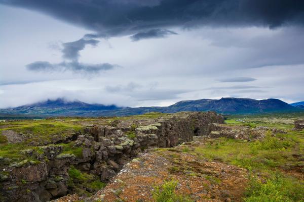 a rocky landscape with mountains in the background and a cloudy sky .