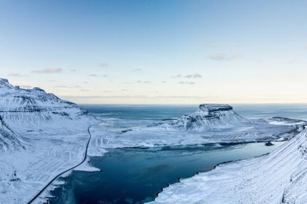 an aerial view of a snow covered mountain with a river running through it .