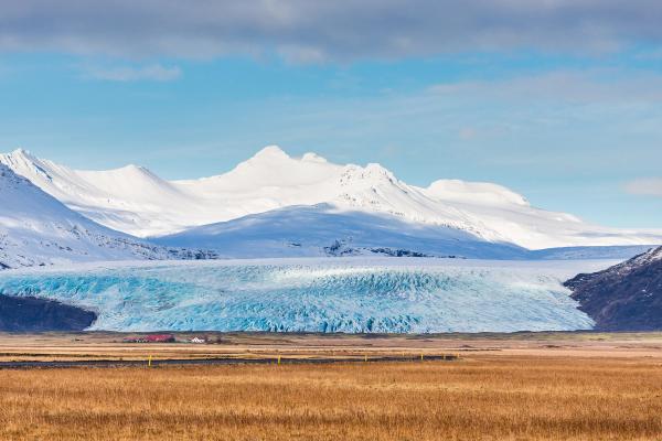 a vast glacier with a mountain covered by snow on the background on a sunny day