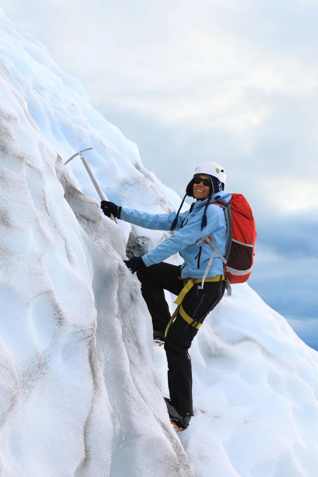 a person climbing on ice in a glacier