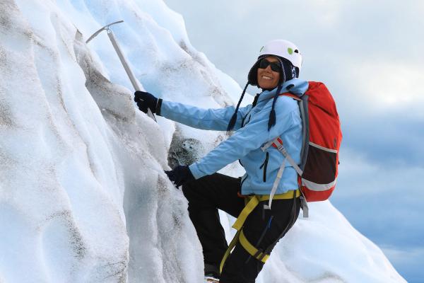 a person climbing on ice in a glacier