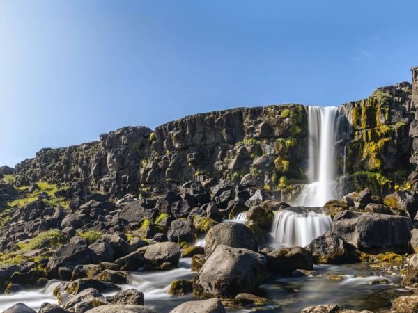 there is a waterfall in the middle of a rocky landscape .
