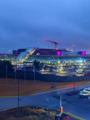 Terminal de aeropuerto moderno y aparcamiento iluminados por la noche.