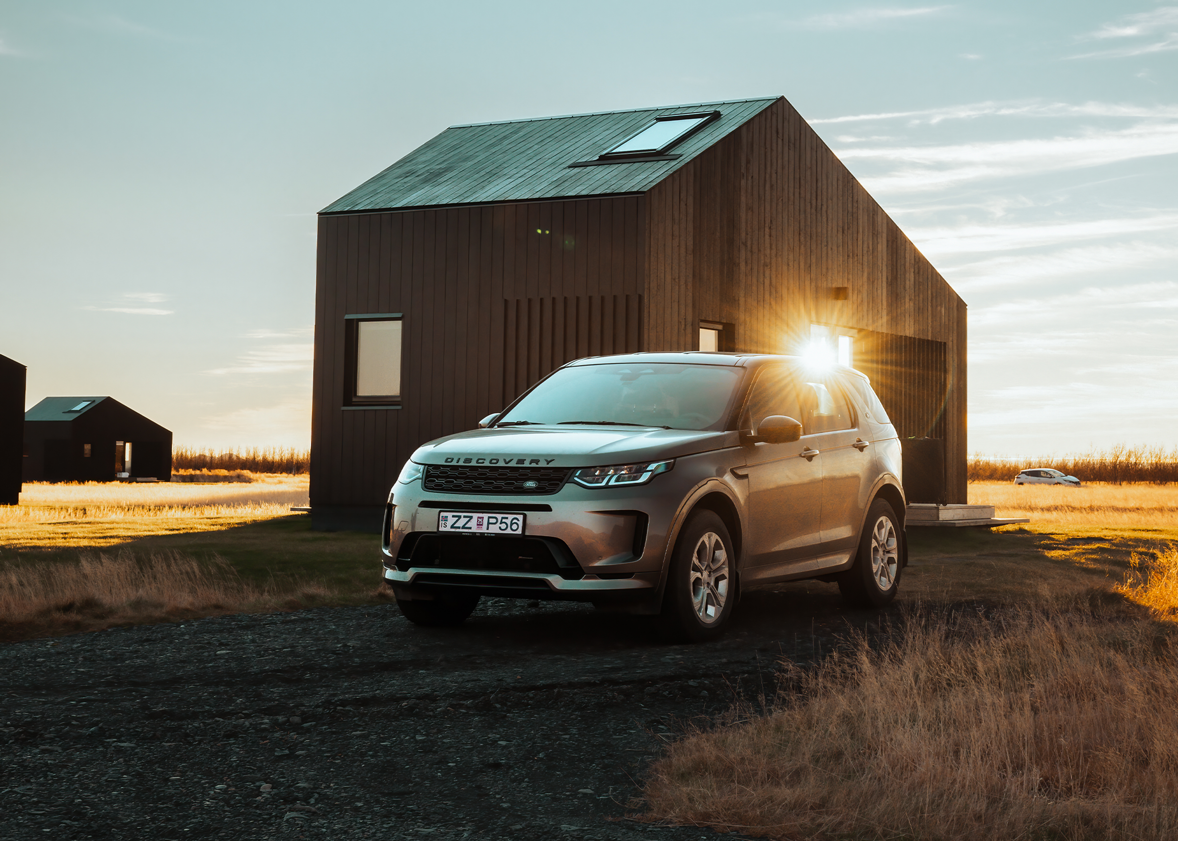 Land Rover Discovery Sport 4x4, geparkt neben einer modernen Hütte