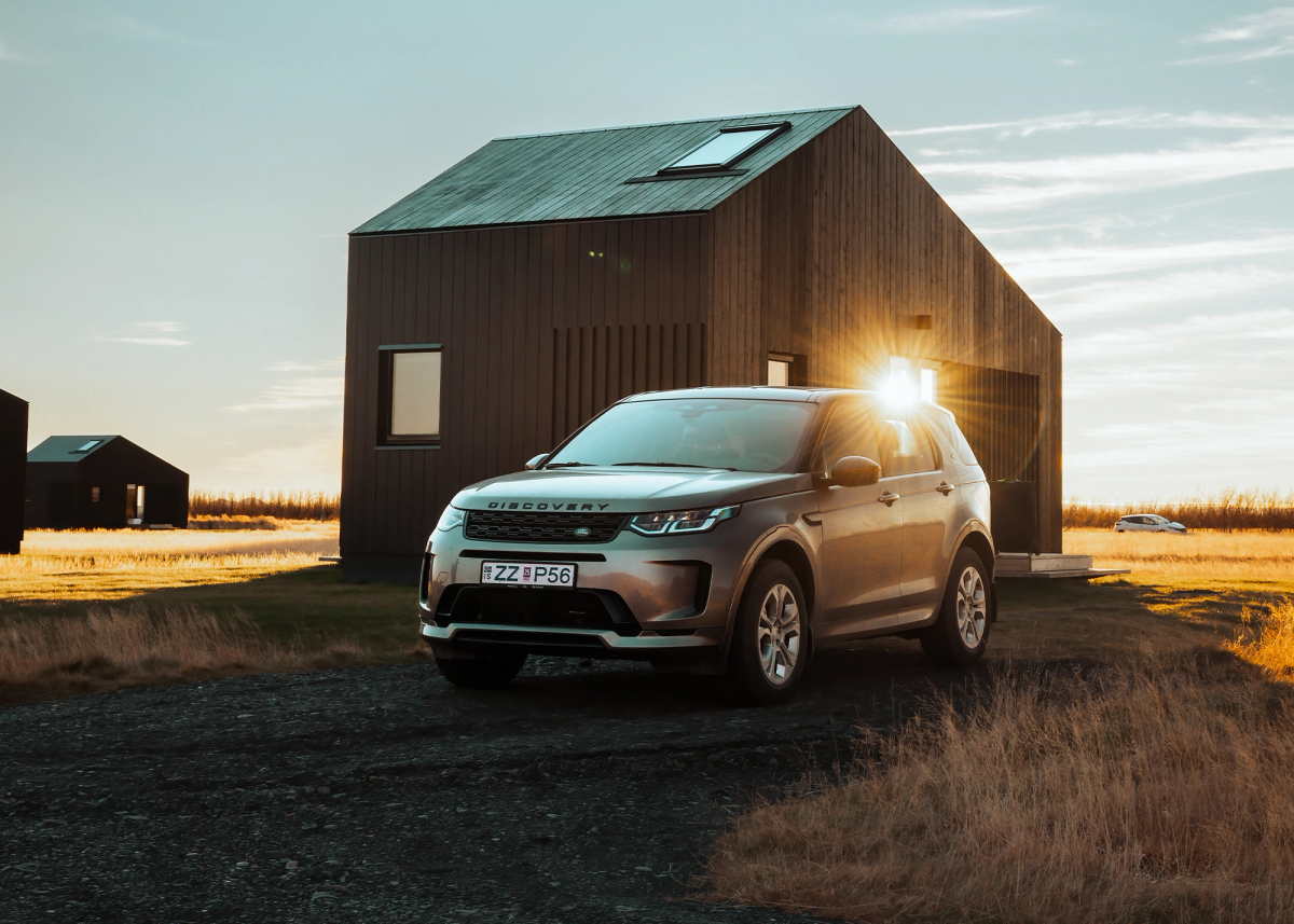 Land Rover Discovery Sport 4x4, geparkt neben einer modernen Hütte