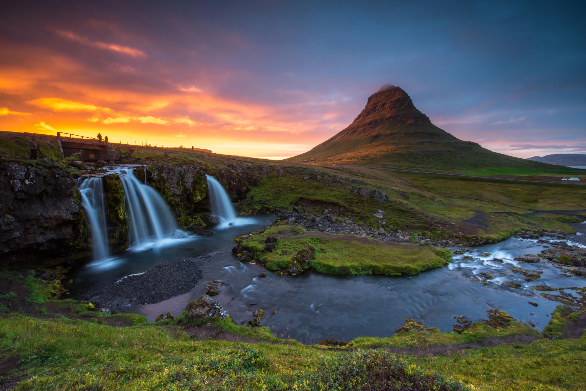 una montaña junto a un río al atardecer