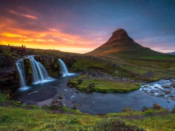 una montaña junto a un río al atardecer