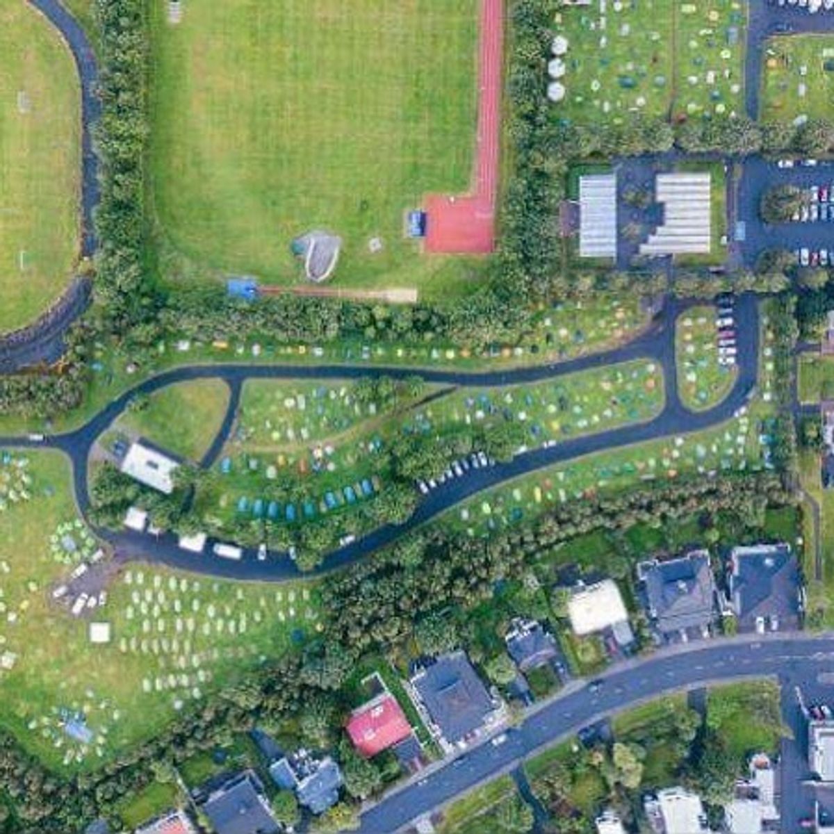 una vista aérea de un parque con muchas tiendas de campaña y un campo de fútbol .