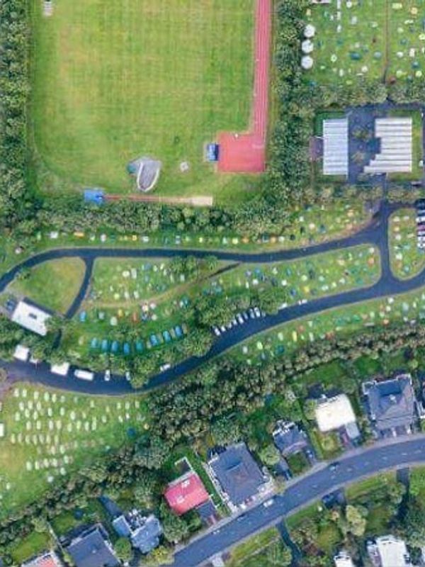 una vista aérea de un parque con muchas tiendas de campaña y un campo de fútbol .