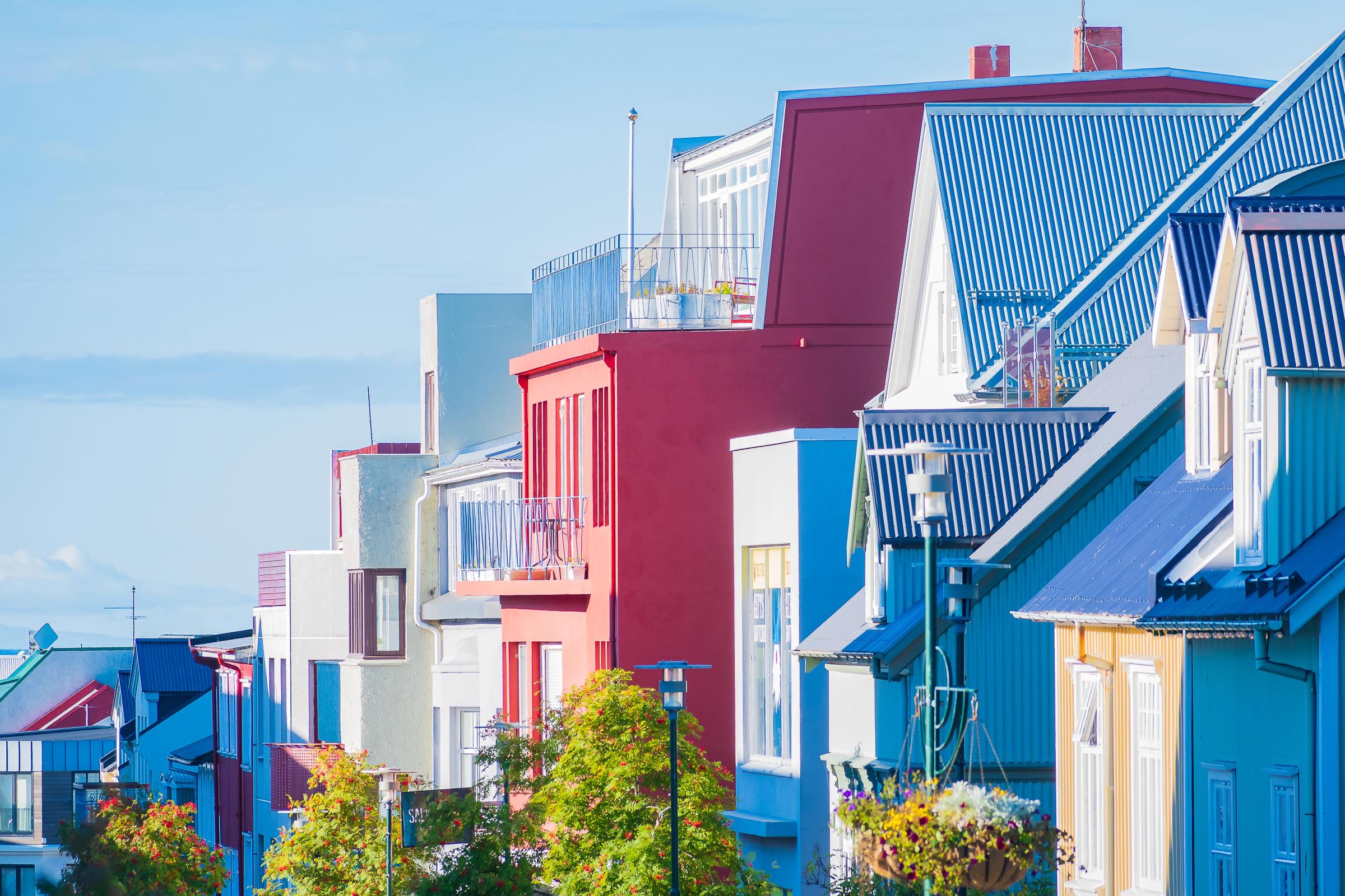 una fila de casas coloridas con techos azules en un día soleado.