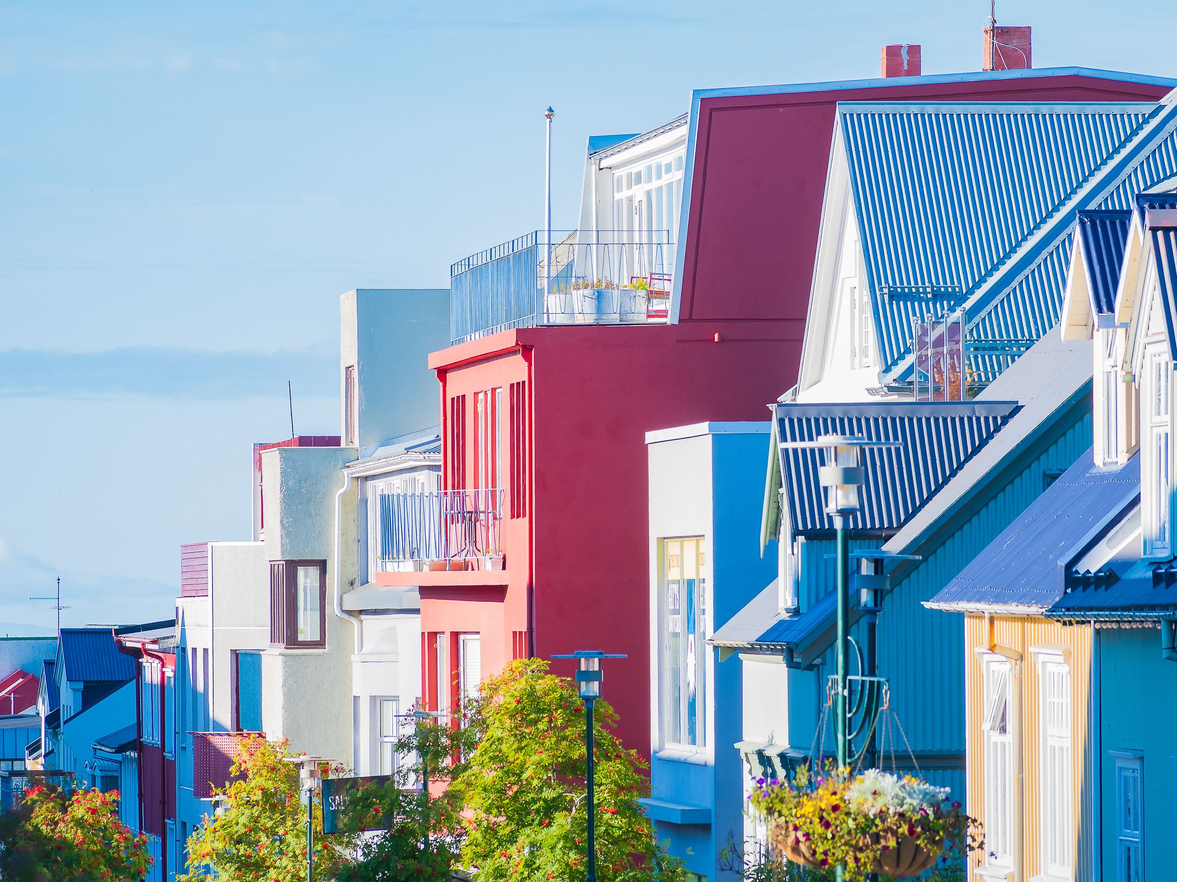 una fila de casas coloridas con techos azules en un día soleado.