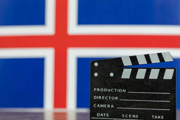 a clapper board is sitting in front of a flag of iceland .