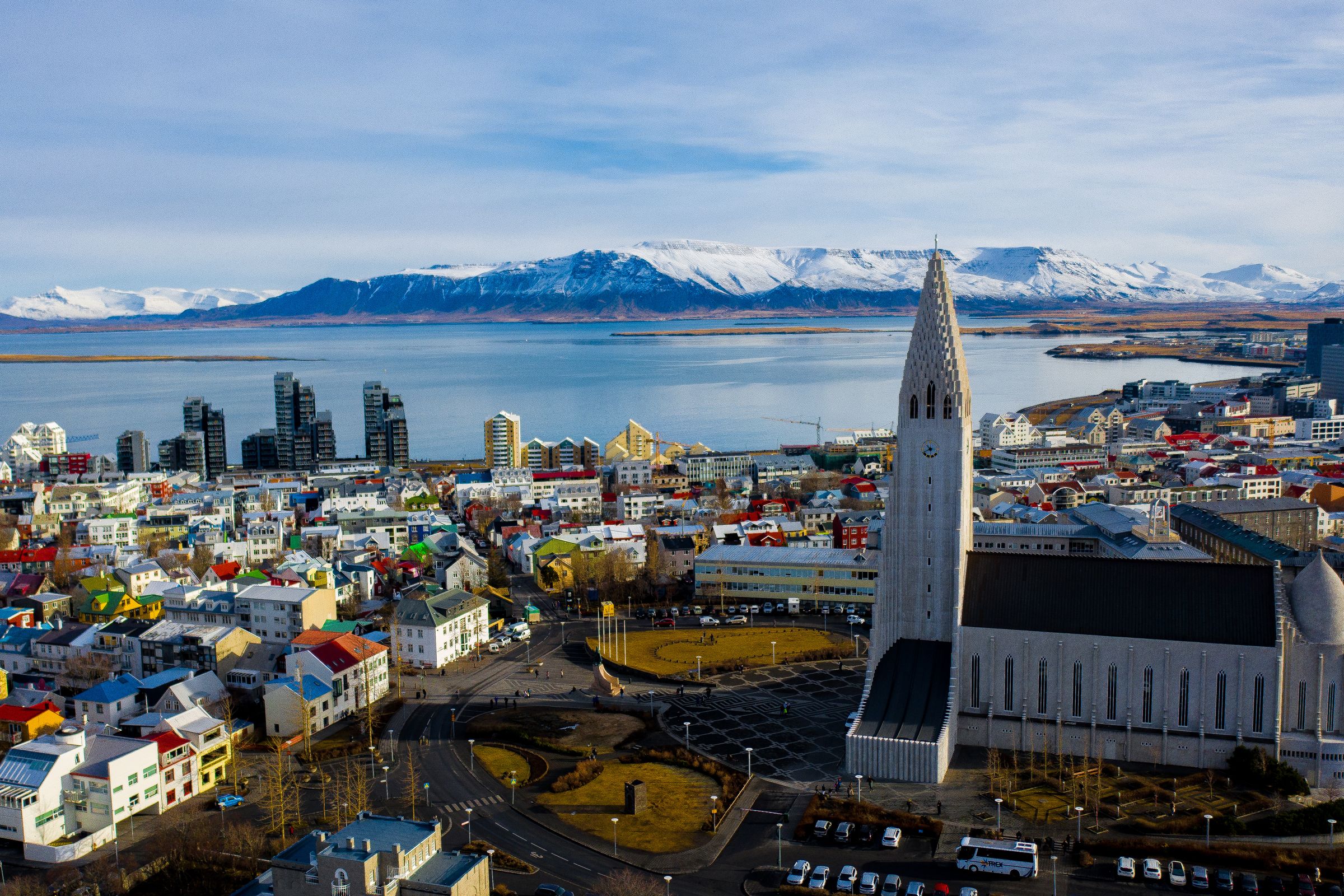 City with a huge church in the middle and the ocean and the mountains in the background