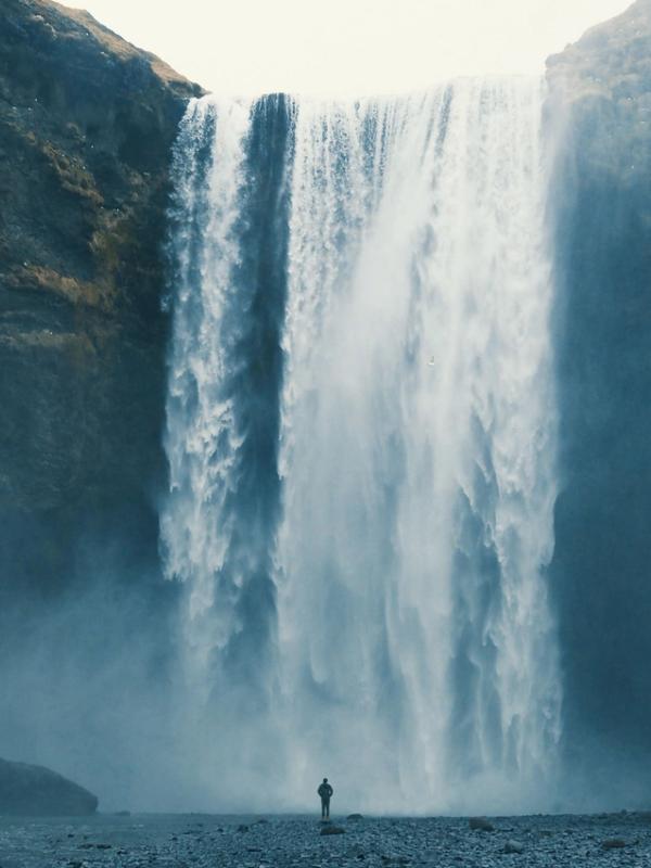 Persona delante de la cascada Skógafoss en Islandia