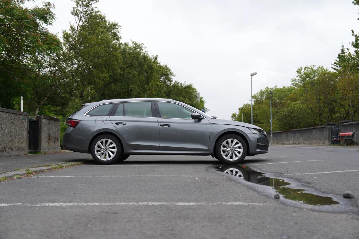 Skoda Octavia-stationbíll séður frá hlið, lagt á bílastæði með tré í bakgrunni