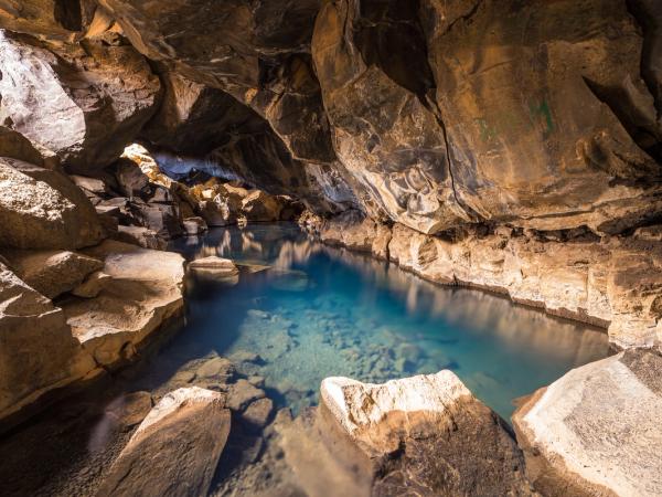 Agua azul cristalina en una cueva rocosa.