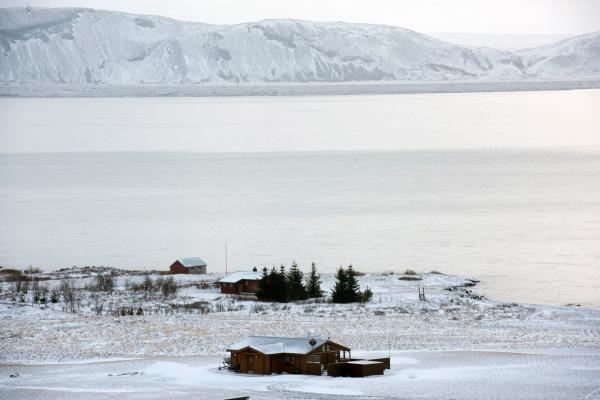 paisaje nevado con casas en la orilla de un lago