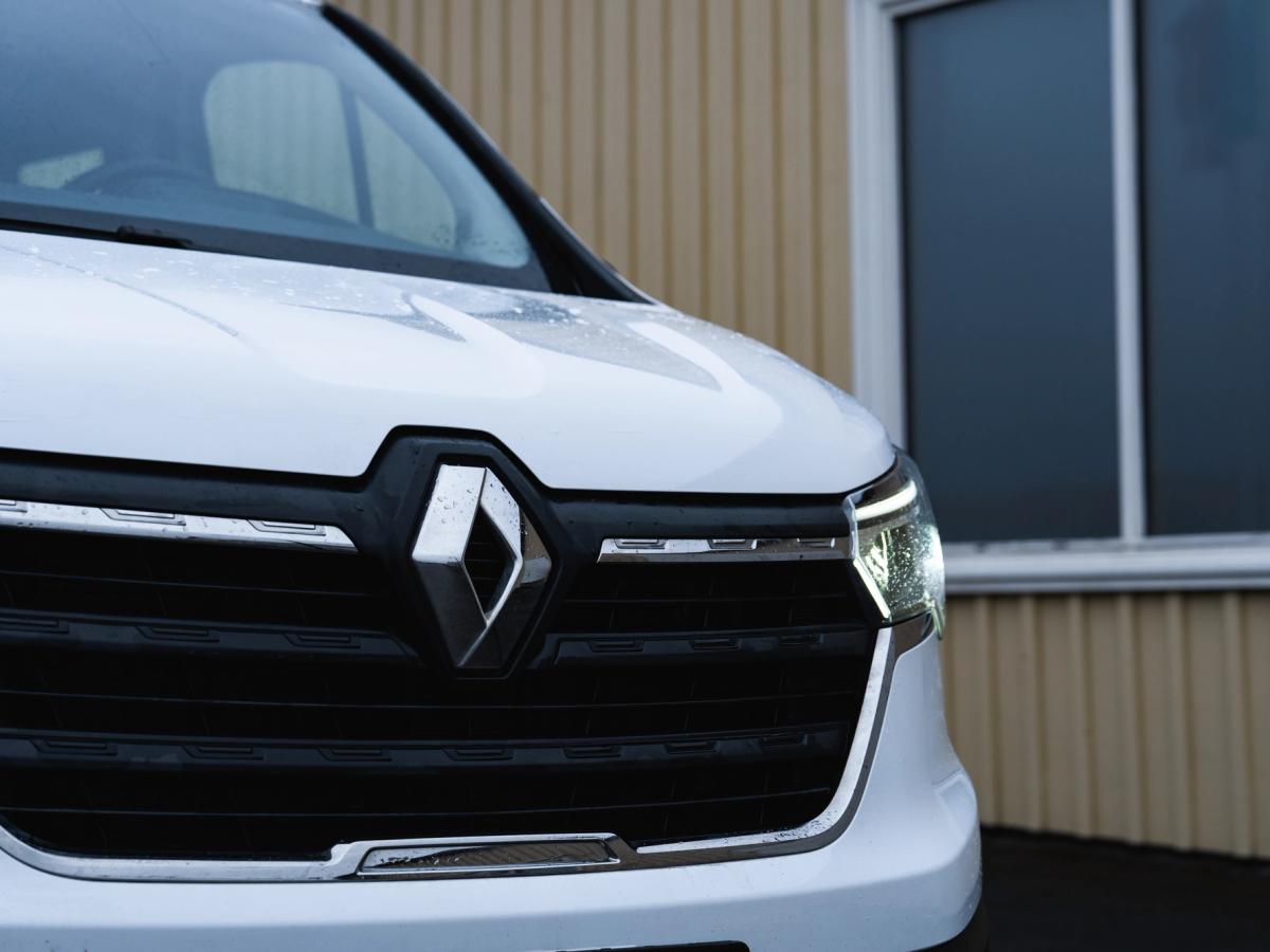 Detalle de la rejilla de tráfico Primer plano de la parrilla delantera, el emblema y el faro de una furgoneta Renault Trafic