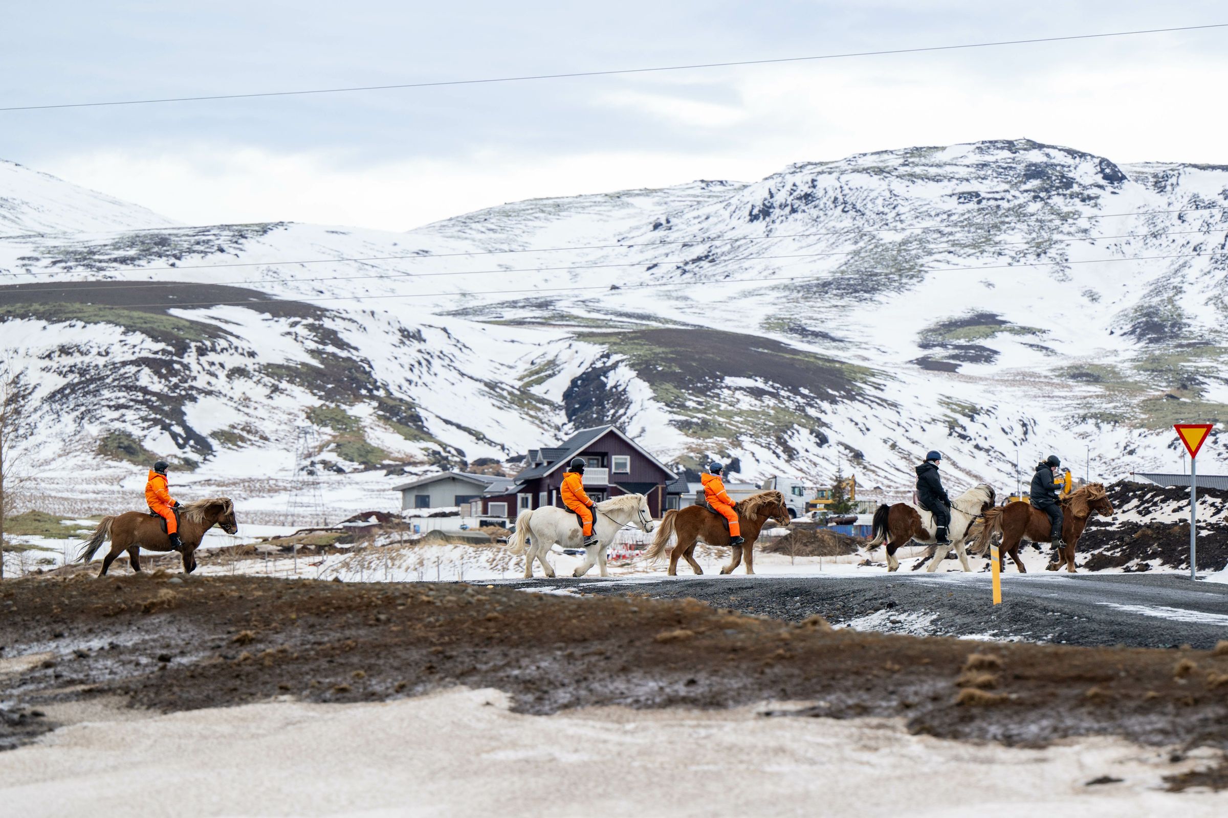 un grupo de personas montando a caballo con montañas nevadas detrás