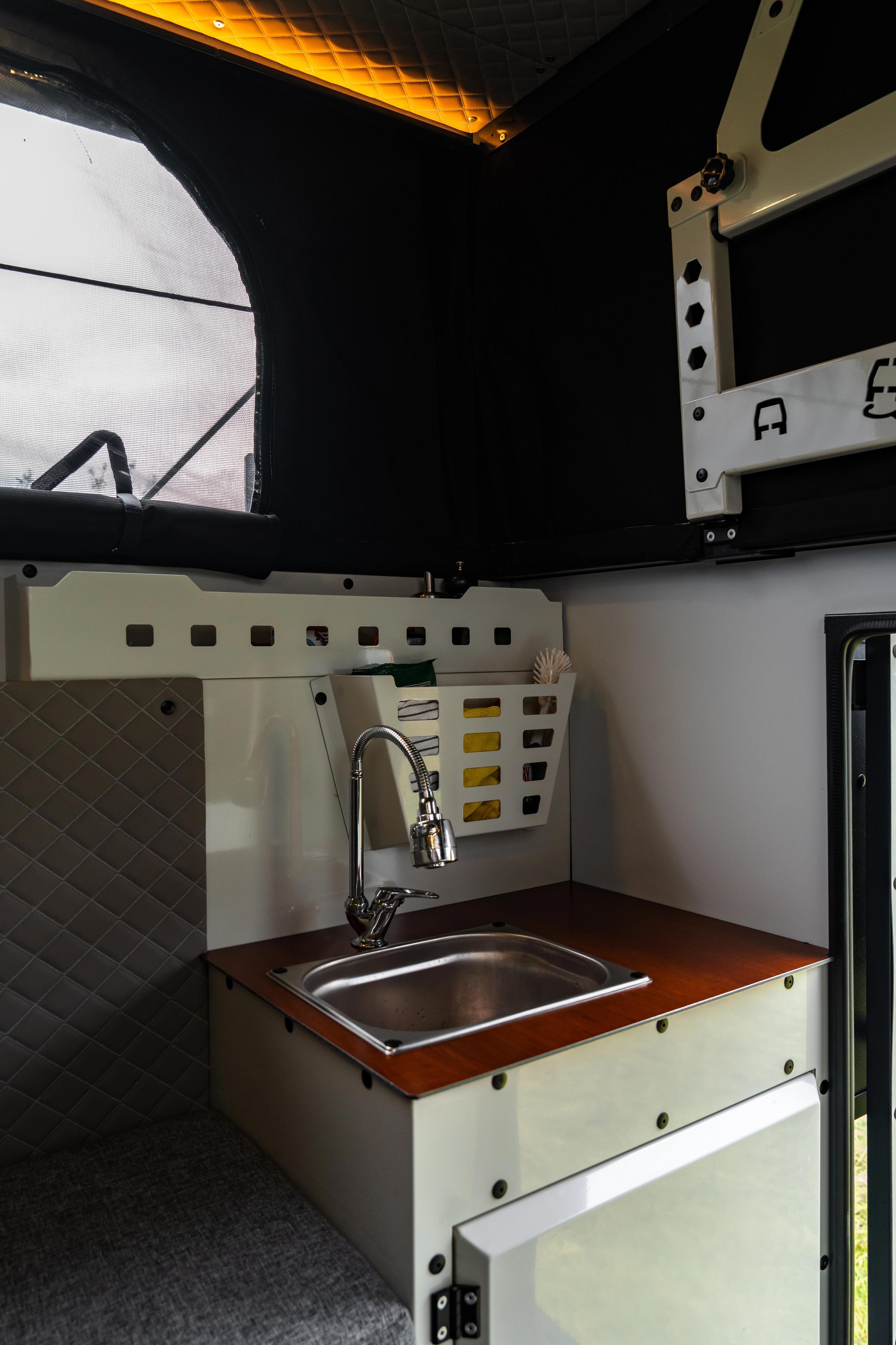Lavabo y encimera Fregadero y grifo de acero inoxidable sobre una encimera de madera, con una cesta de almacenaje encima