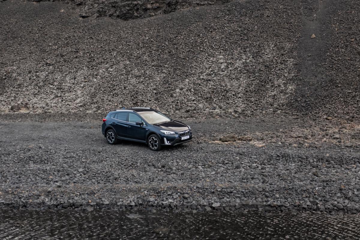 斯巴鲁 XV 砂石路面视图 冰岛租赁的斯巴鲁 XV SUV 停在岩石坡前的碎石地面上