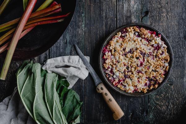 a rhubarb cake on a table next to rhubarb stalks