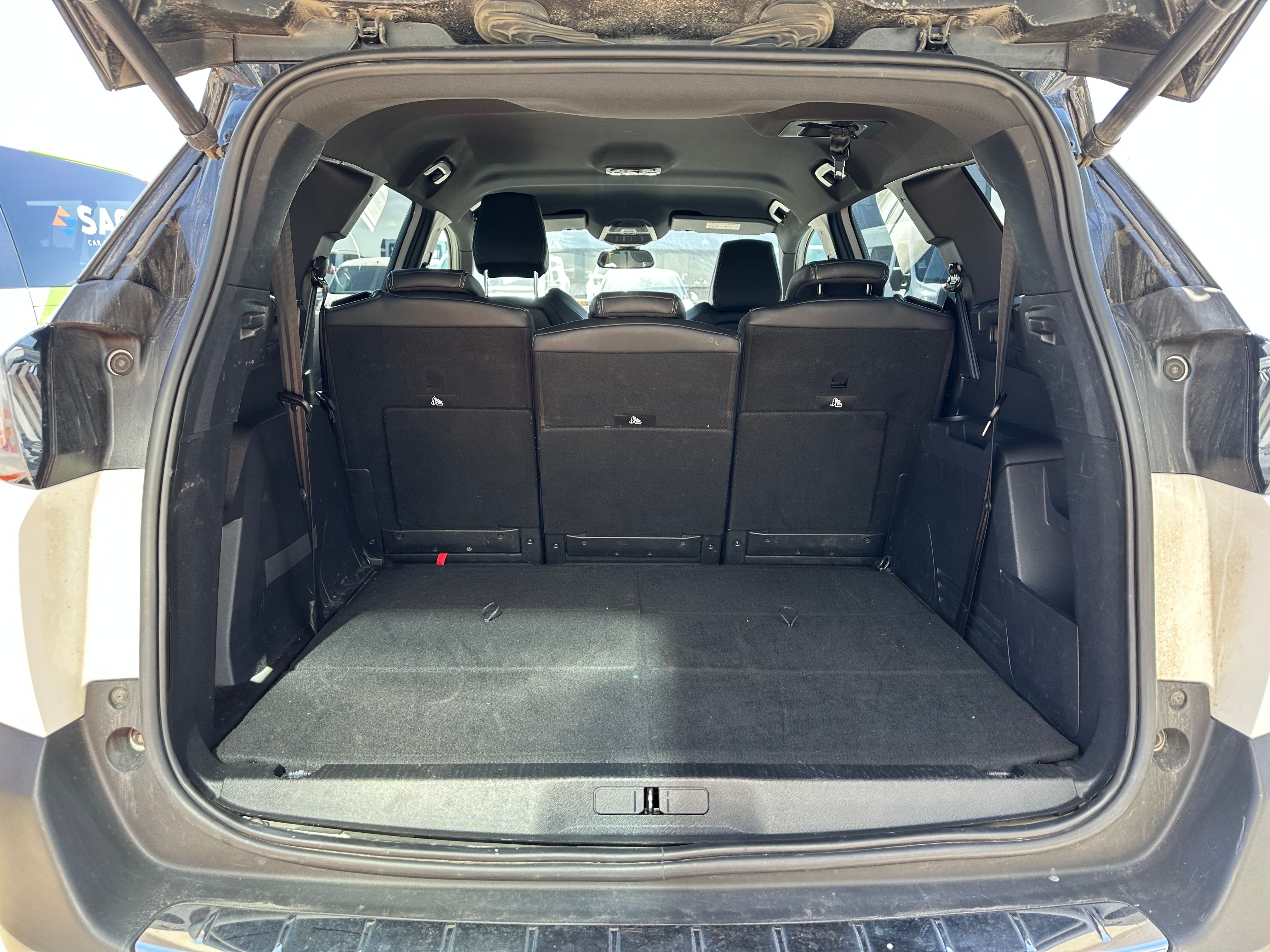 View of a car's trunk with the rear seats folded down, creating a large, flat cargo area.