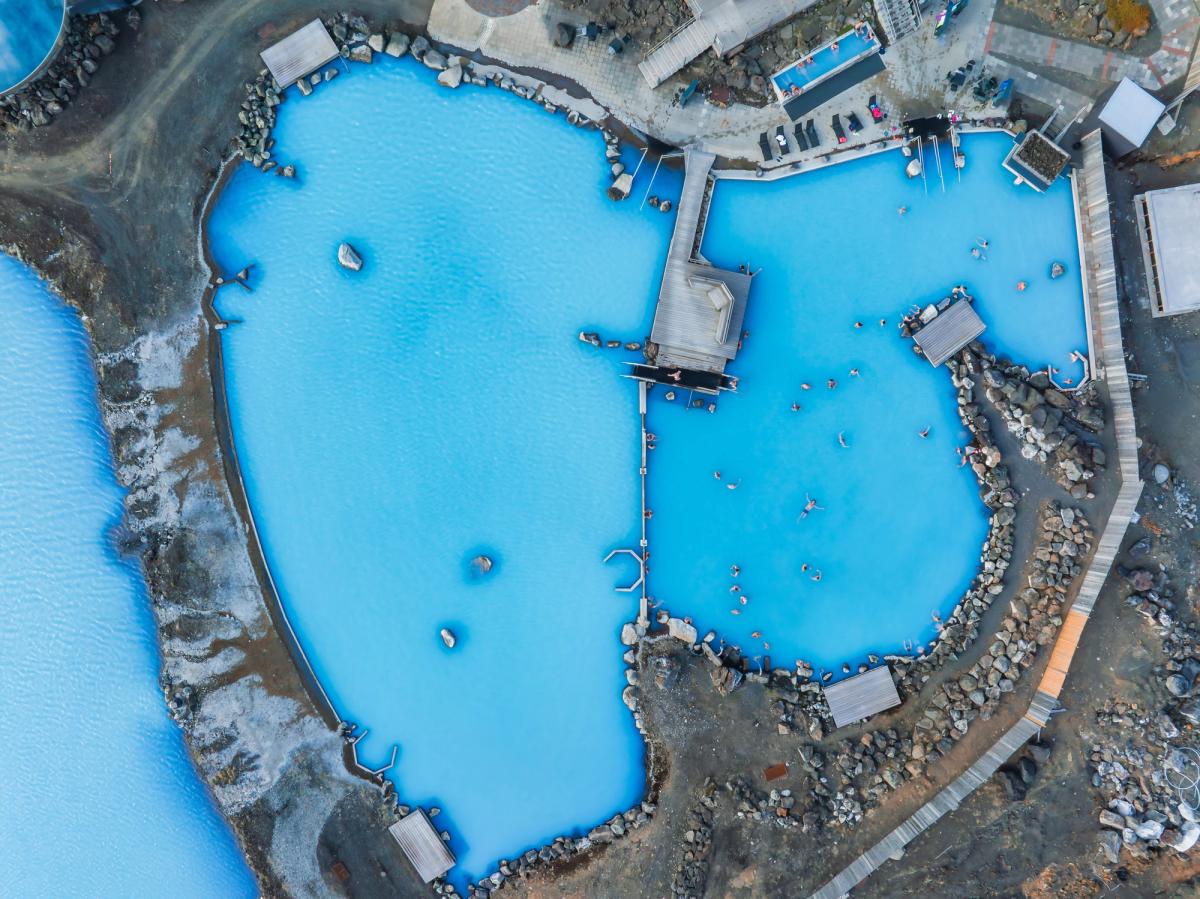 An aerial view of the blue lagoon with people swimming in it 