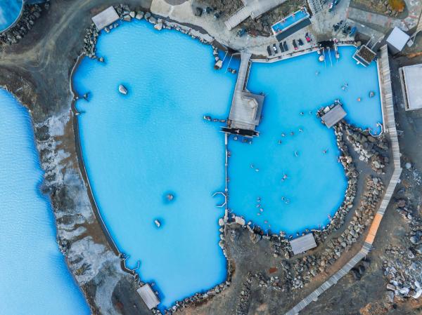 An aerial view of the blue lagoon with people swimming in it 