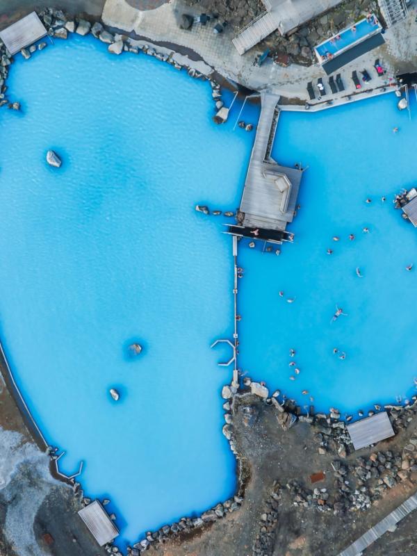 An aerial view of the blue lagoon with people swimming in it