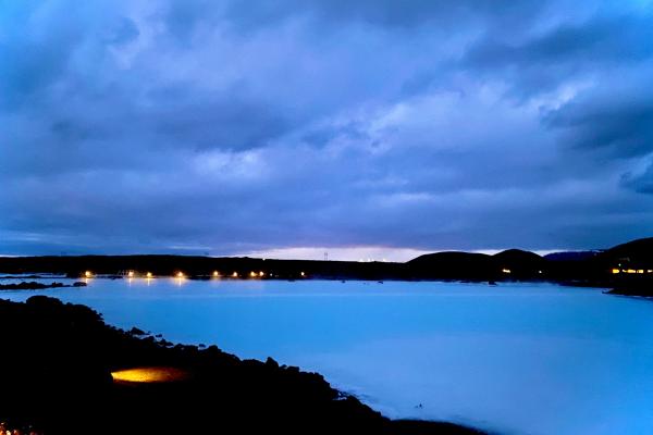a sunset over a lake with rocks and mountains in the background .