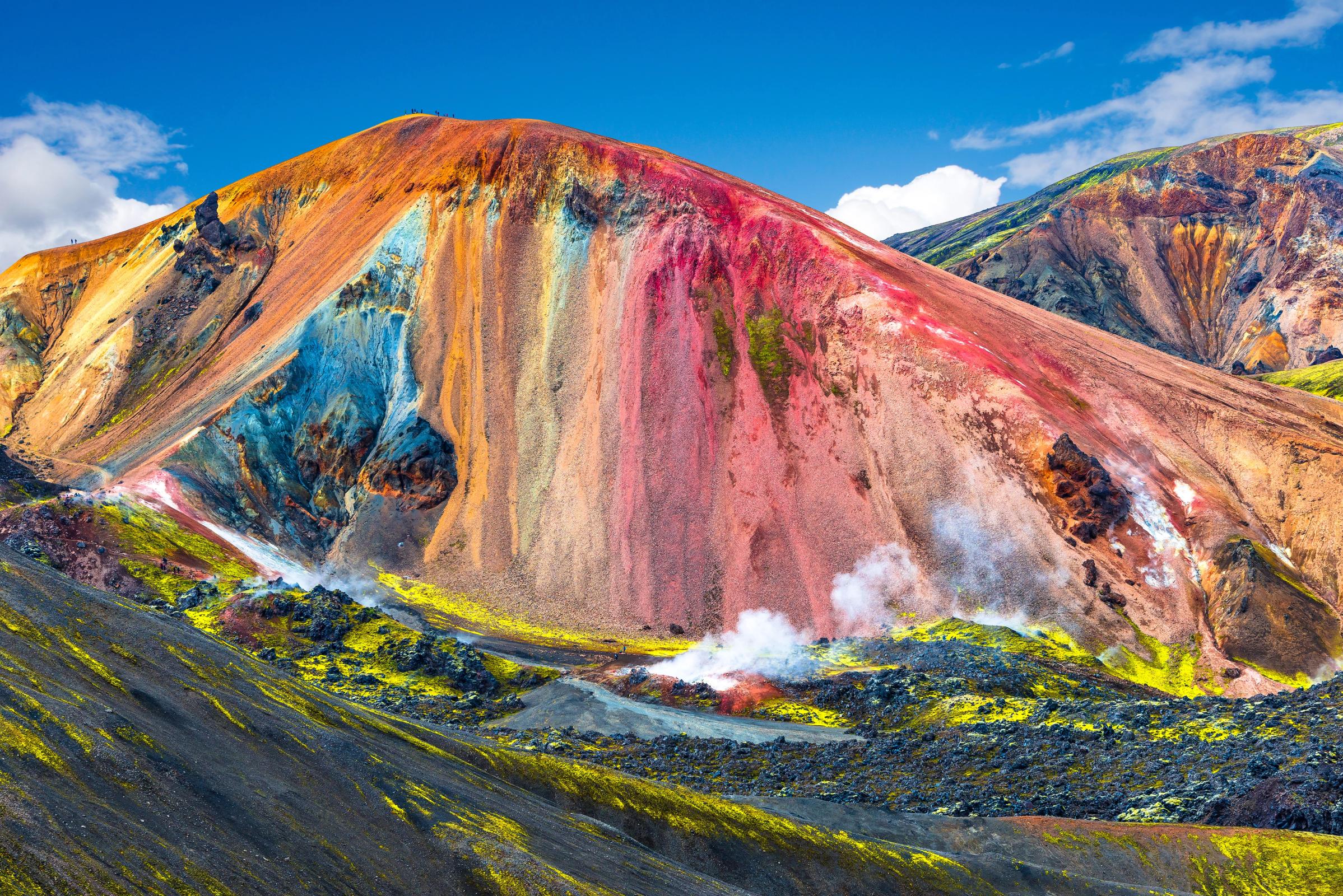 a hill with different color layers on a clear day