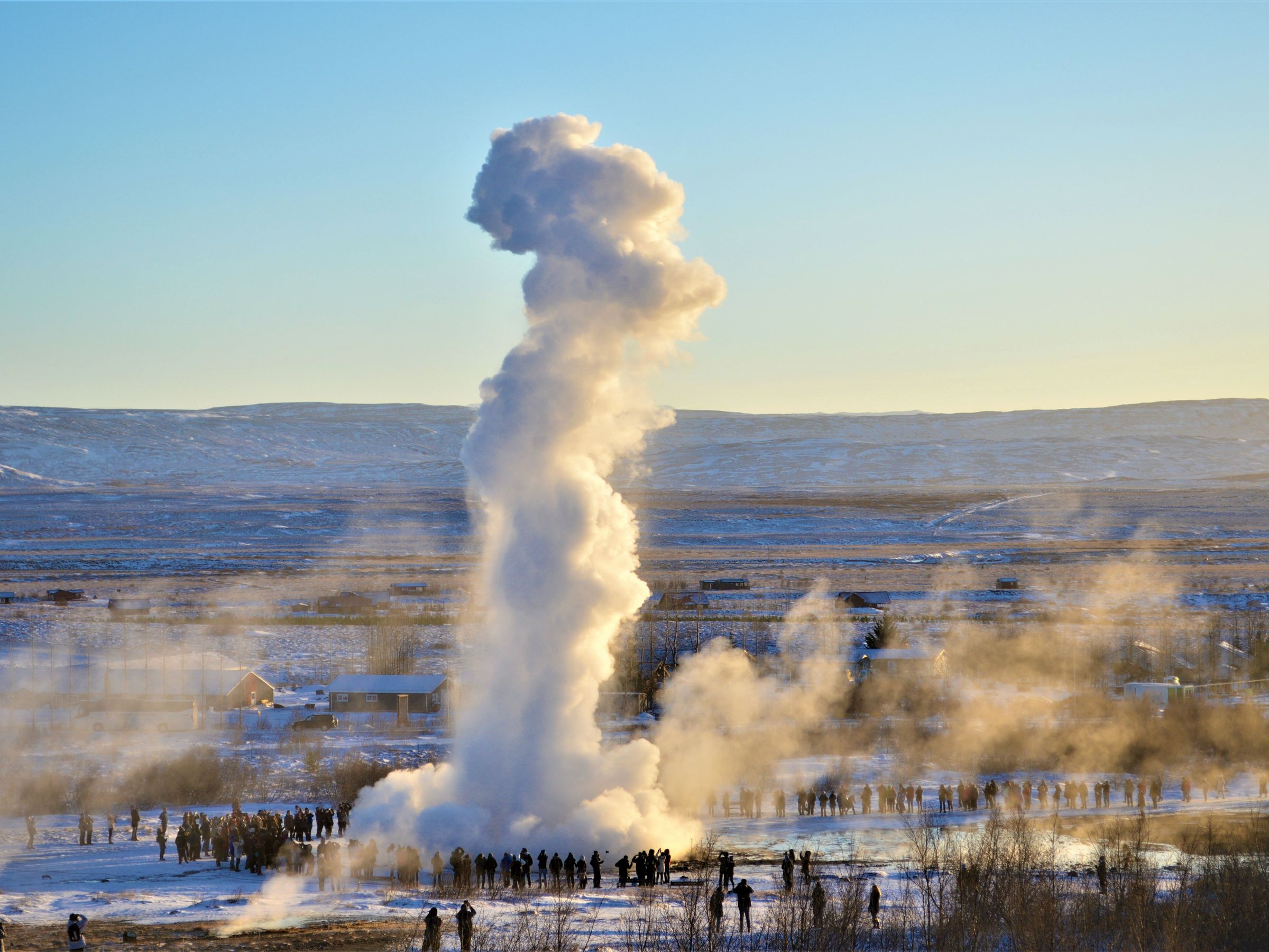 Foule rassemblée autour d'un grand geyser