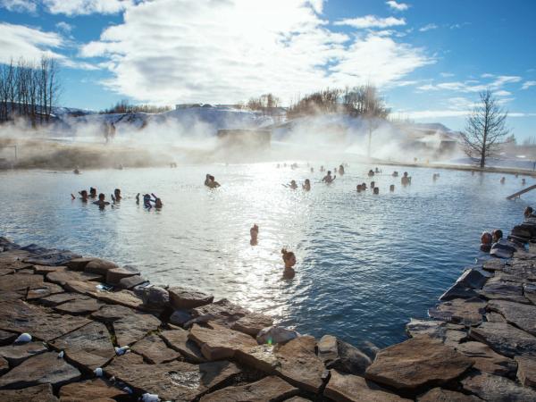 a group of people are swimming in a hot spring .
