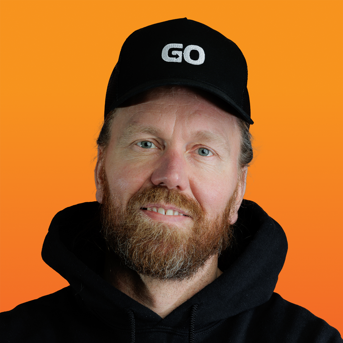 a man with a beard wearing a black hat that says go