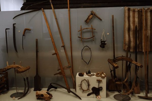 a variety of old farming tools are on display in a museum .
