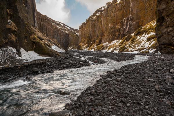 a river flowing through a canyon surrounded by rocks and mountains .