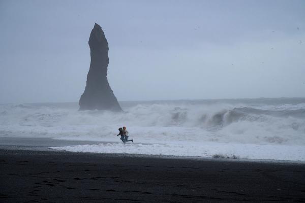 Turistas huyendo de las olas de Reynisfjara