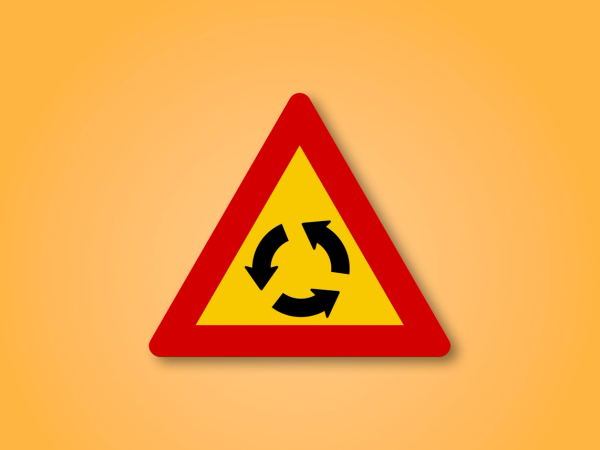 Red and yellow triangle road sign with an Roundabout in the middle. This road sign means Roundabout ahead